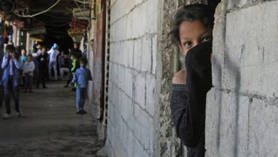 طفلة سورية لاجئة تغطي وجهها كإجراء وقائي ضد فيروس كوفيد 19، بينما تعيش في مبناٌ تحت الإنشاء، صيدا، لبنان، 17 مارس 2020. محمود الزيات، وكالة الأنباء الفرنسية.