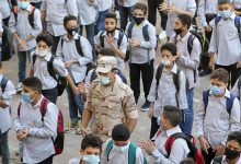 An army member wearing a protective mask stands guard between students as they attend the first day at Al Saadeya school, following months of closure due to the Covid-19 outbreak, Cairo, Egypt, 17 October 2020. Reuters, Mohamed Abd El Ghany.