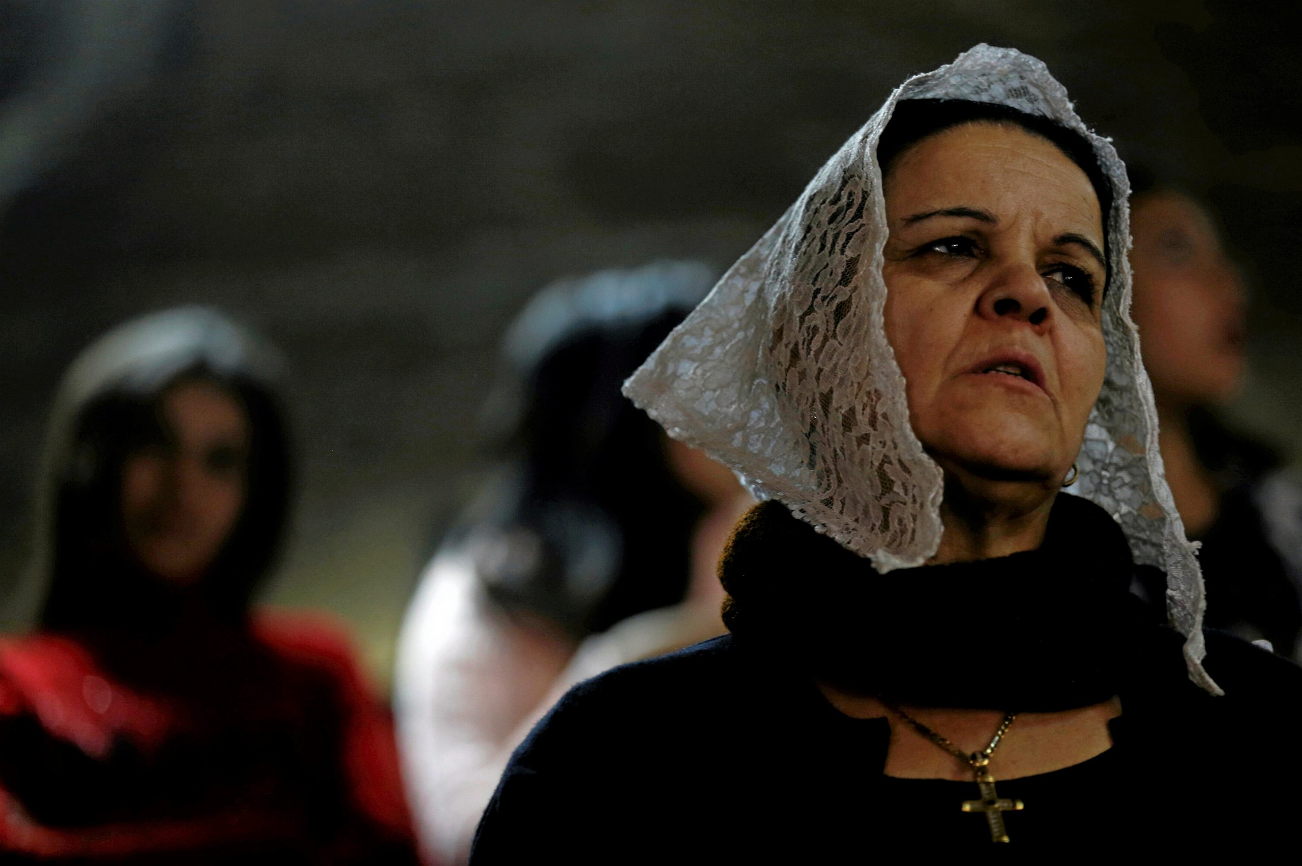 An Egyptian Christian woman attends Coptic Christmas eve mass in a church of the Samaan el-Kharaz Monastery in the Mokattam Mountain area, Cairo, Egypt, 6 January 2017. Reuters, Amr Abdallah Dalsh.