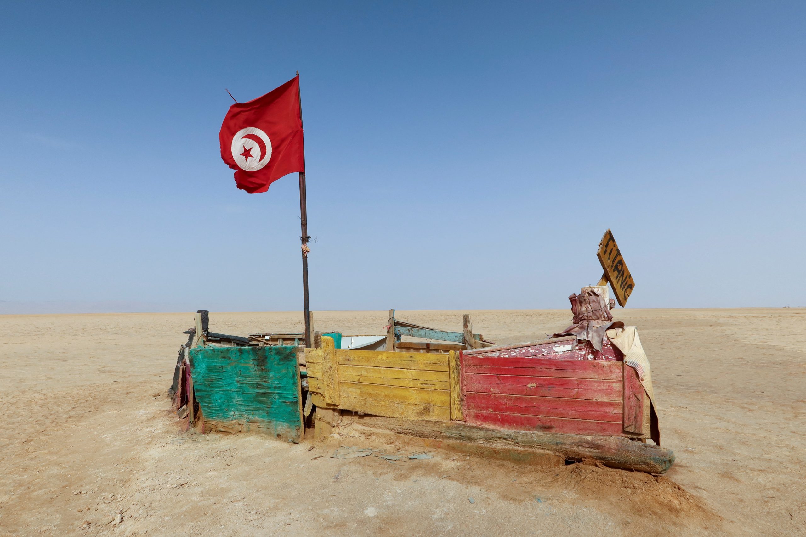العلم التونسي يرفرف فوق قارب موقت ببحيرة شط الجريد، جنوب تونس، 29 أغسطس، 2022. رويترز، جهاد عبد القوي.