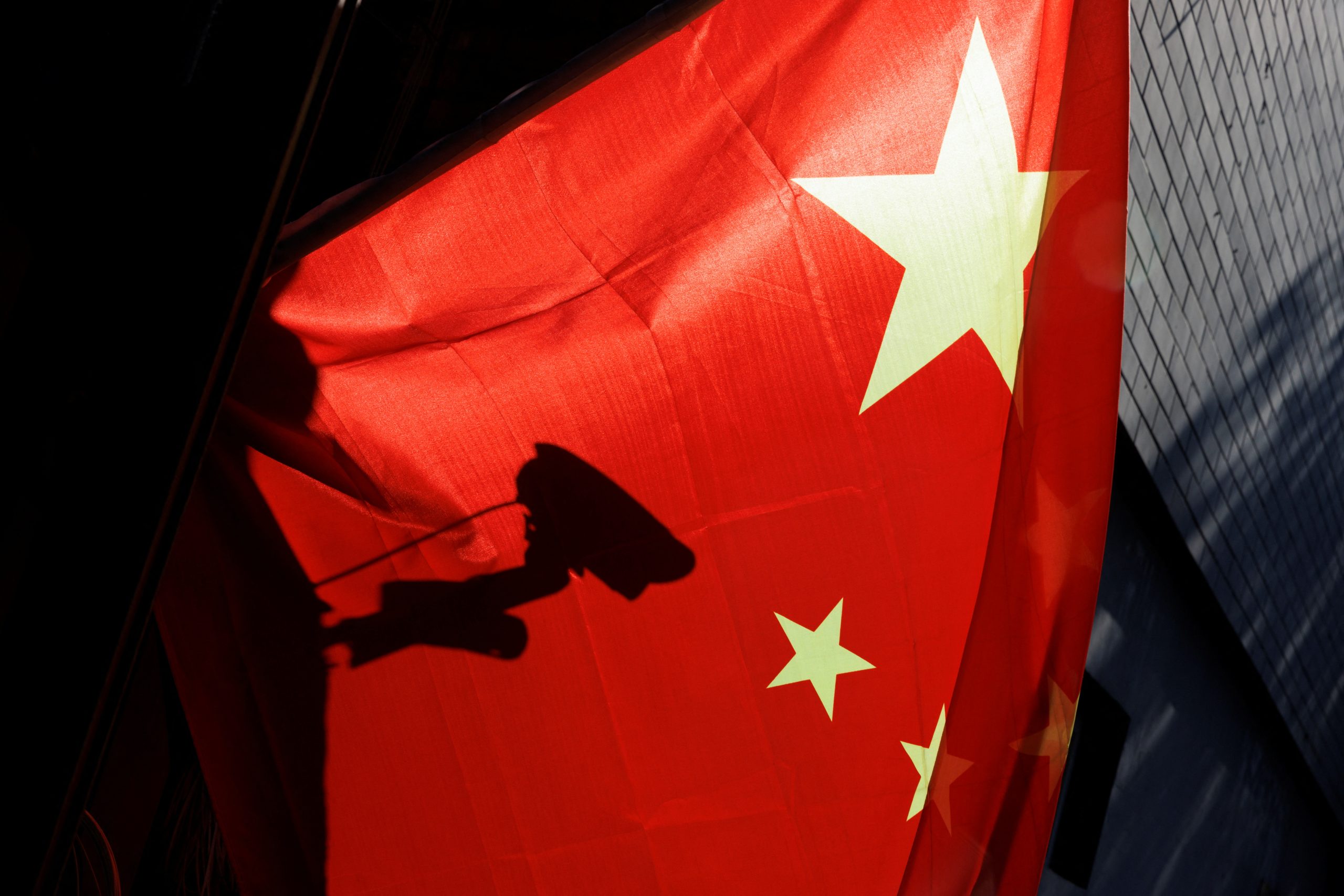 ظل كاميرا للمراقبة يظهر خلف العلم الصيني في بكين، الصين، 3 نوفمبر 2022. رويترز، توماس بيتر.